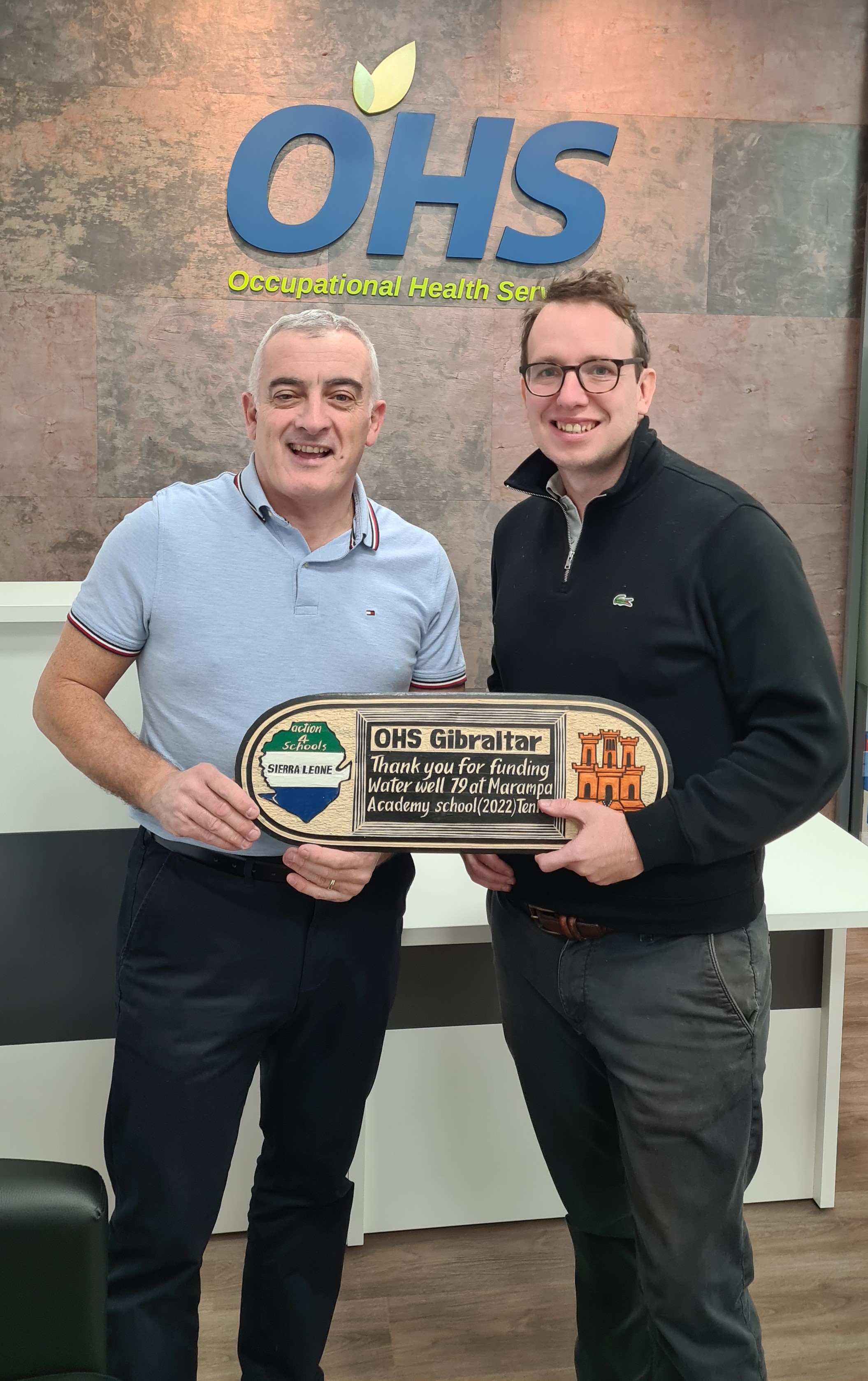 Nov. 2022 - OHS funded Water Well 79 at Marampa School and Action4schools present Nick Culatto of OHS with a specially hand crafted wooden plaque.