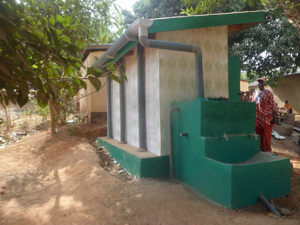 Amputee camp chairman inspecting newly constructed school latrine